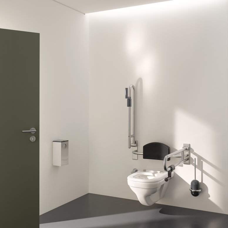 Barrier-free WC in public areas equipped with folding support handles, back support and toilet brush